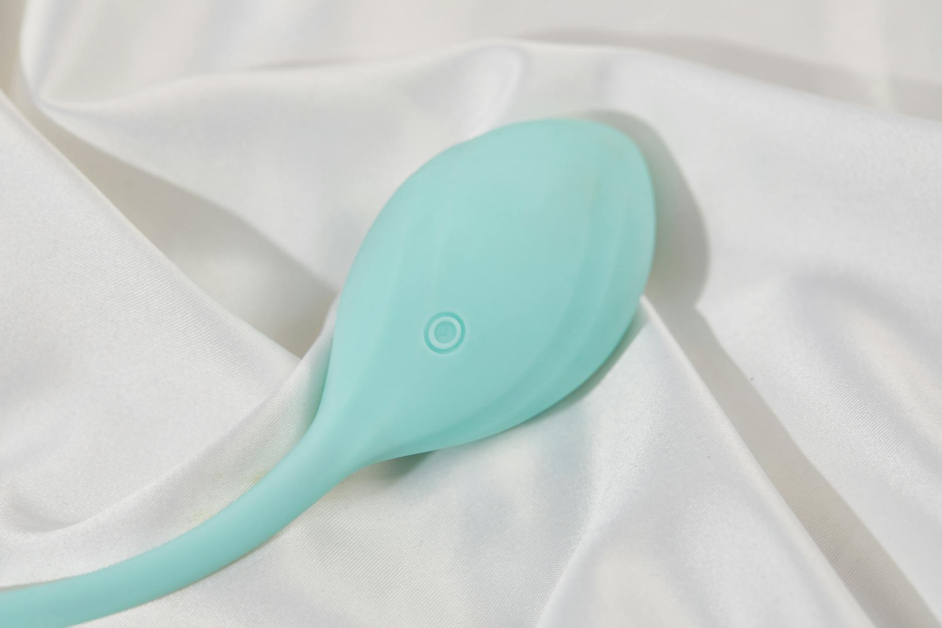 Teal lemon vibrator on white silk fabric