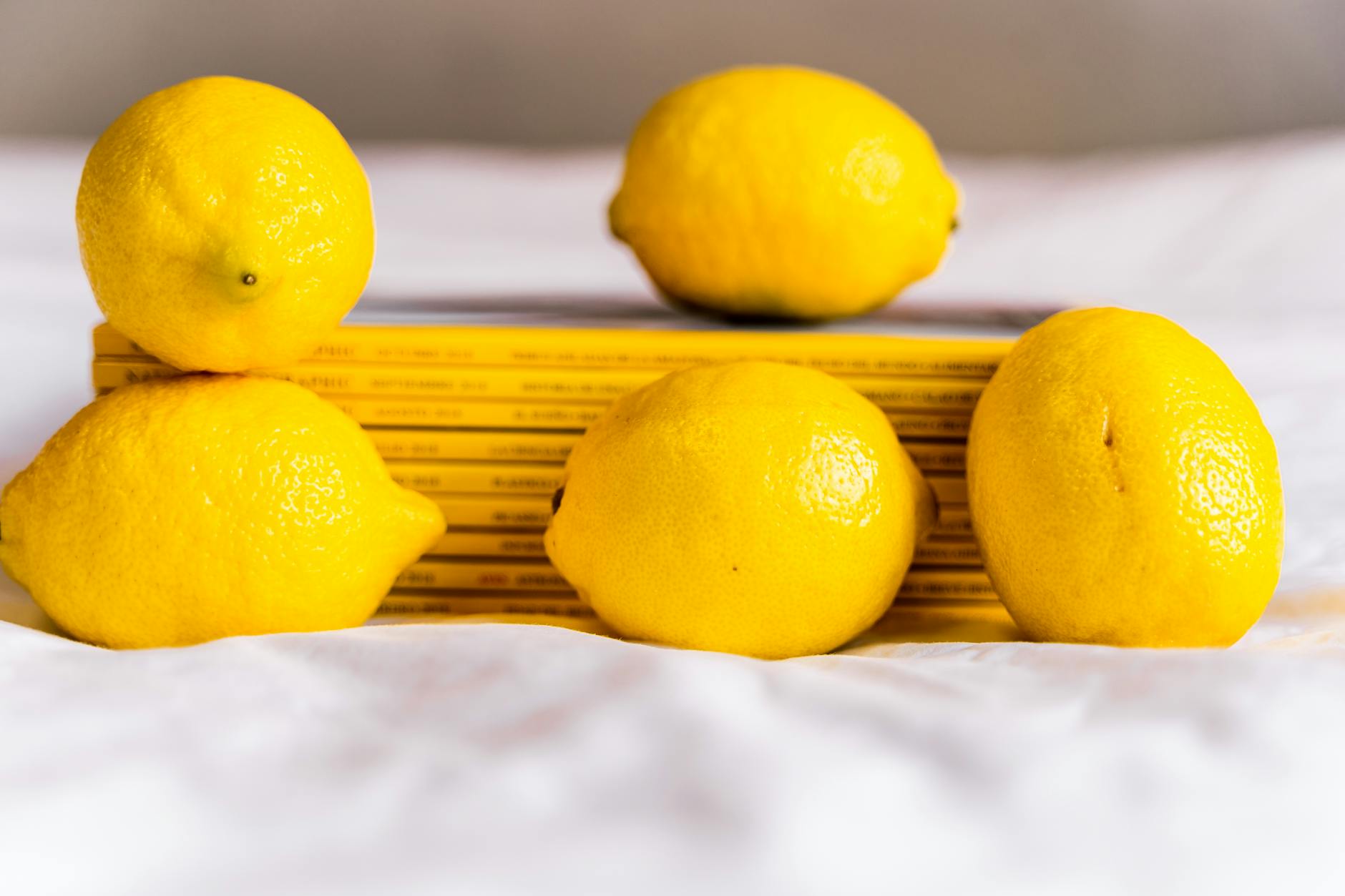 Teal lemon vibrator resting on white silk fabric